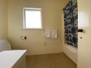 a bathroom with a toilet and a window at KBHH - Beachfront Paradise - BUR1 in Ohope Beach +12 photos