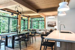 a living room with a large table and chairs at Chalet Van Haven Nature Lake Hot Tub Fire Pit Game Room in Labelle