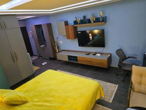a bedroom with a bed and a tv on a wall at Pretty Modest Apartment in Prizren