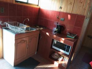 a small kitchen with a sink and a microwave at Eco Cabañas Algarrobo in Algarrobo