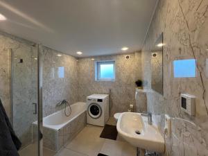 a bathroom with a tub sink and a washing machine at Haus am Park Dreieich in Dreieich +7 photos