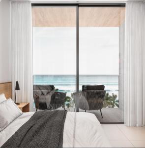 a bedroom with a bed and a view of the ocean at porto life 2 resort in Ipojuca
