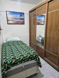 a bedroom with a bed and a wooden cabinet at Studio Asa sul 7 204 in Brasilia