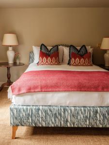 a bedroom with a large bed with red pillows at The Fleur de Lys in Cranborne