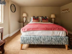 a bedroom with a large bed with red pillows at The Fleur de Lys in Cranborne