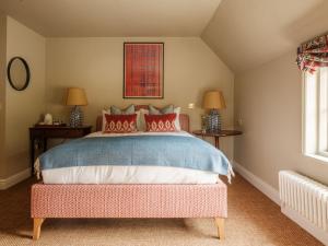 a bedroom with a large bed with red pillows at Fleur de Lys Inn, Cranborne in Cranborne