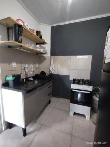 une petite cuisine avec un évier et une cuisinière dans l'établissement Casa Beira Mar, à Parati