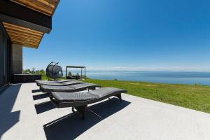 een rij banken aan de zijkant van een huis bij Chalet L'Eaurizon Charlevoix in La Malbaie