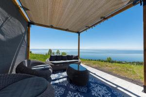 een afgeschermde veranda met uitzicht op de oceaan bij Chalet L'Eaurizon Charlevoix in La Malbaie