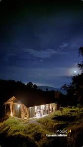 a barn at night with the moon in the sky at Glamping Bosque de helechos, privacidad y cercanía in Manizales