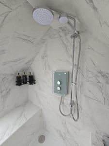 a shower in a bathroom with a white marble wall at 5 Bed Cottage Free Parking in Stainforth +31 photos