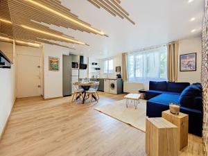 a living room with a blue couch and a table at Le Lodge de l'One in Luchon