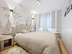 a bedroom with a large bed with christmas trees on the wall at Le Lodge de l'One in Luchon +3 photos