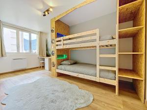 a bedroom with two bunk beds and a rug at Le Lodge de l'One in Luchon