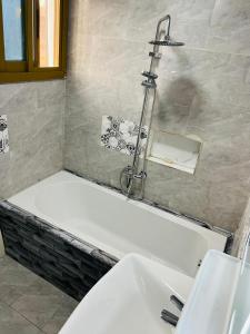 a bath tub with a faucet above a sink at résidence o-calme in Yaoundé +68 photos