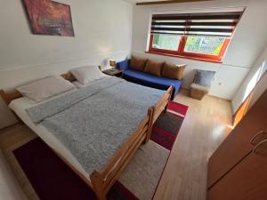 a bedroom with a large bed and a blue couch at Apartment near center in Sarajevo
