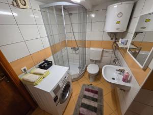 a small bathroom with a washing machine and a sink at Apartment near center in Sarajevo