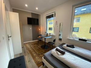 a room with two beds and a table in it at Renovierte Unterkunft am Rhein in Koblenz - eigenes Bad, Küche, Wifi - 1 OG in Koblenz