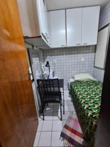 a small room with a bed and a table and chair at Quarto Capsula 1 207 in Brasília