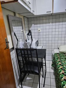 a black chair in a room with a mirror at Quarto Capsula 1 207 in Brasília