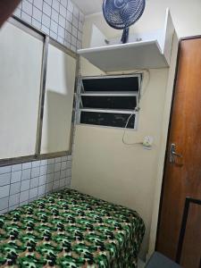 a small room with a bed and a mirror at Quarto Capsula 1 207 in Brasília