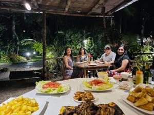 a group of people sitting at a table with food at Eden Treehouse in Mindo