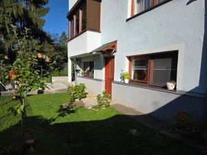 a house with a green yard with a window at Apartment near center in Sarajevo