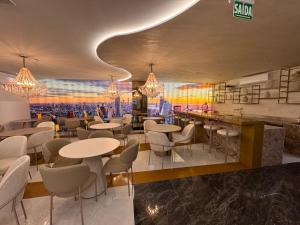 a restaurant with tables and chairs and a bar at Flats New York Meia Praia Itapema in Itapema