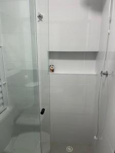 a shower with a glass door in a bathroom at Apartamento Tibagy in Guarulhos +16 photos