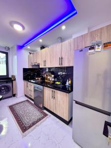 a kitchen with a refrigerator and a purple light at Chic & Cozy Apartment in Tangier in Oulad Akkou