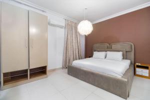 a bedroom with a bed and a chandelier at Tastefully furnished 3bedrooms Ikate Lekki in Lekki