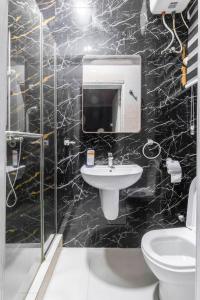 a black marble bathroom with a sink and a toilet at Tastefully furnished 3bedrooms Ikate Lekki in Lekki +22 photos