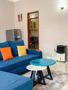 a living room with a blue couch and a table at Shalom Homes in Kampala
