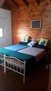 two beds in a room with wooden walls at Guanaco Inn in El Calafate
