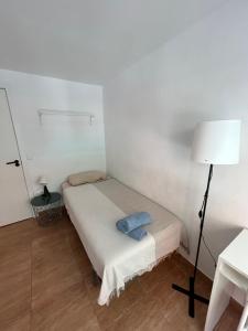 ein kleines weißes Zimmer mit einem Bett und einer Lampe in der Unterkunft Habitación privada en piso compartido cerca del Centro Alicante in Alicante + 12 Fotos