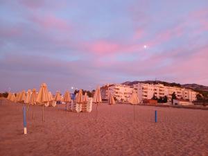 a group of umbrellas and chairs on a beach at Cozy room in Denia