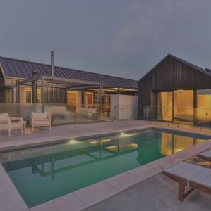 a swimming pool in front of a house at Riverslea in Wanaka