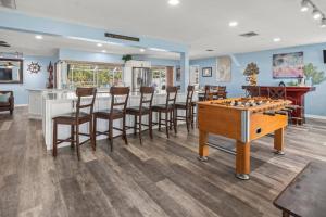 a room with a bar and a game table and chairs at Pirates Den in Apollo Beach