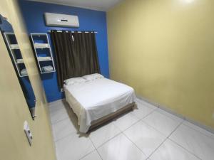 a small bedroom with a bed and a blue wall at Boa vista, Olímpico - Apartamento mobiliado in Boa Vista