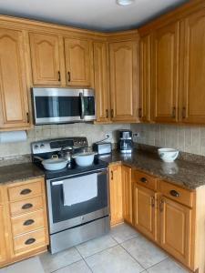 a kitchen with wooden cabinets and a stove top oven at Cozy Gurnee Home Near Six Flags and Base in Gurnee