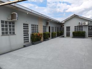 a white building with shuttered windows and plants at Boa vista, Olímpico - Apartamento mobiliado in Boa Vista