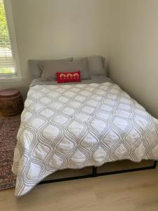 a bed with a white comforter and a red pillow at Cozy Gurnee Home Near Six Flags and Base in Gurnee