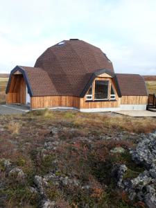 a house with a gambrel roof on top of a field at Hálfkúla Goðafoss in Húsavík