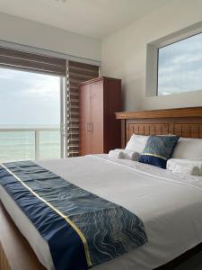a bedroom with a large bed with a large window at Beachfront Two Bedroom Apartment near Colombo area in Pulluhena