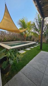 a swimming pool with a hammock in a backyard at Casa Praia Paredon in El Naranjo