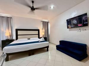 una camera da letto con un letto e un divano blu di Bright Studio with Shared Pool Access a Mérida