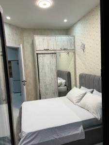a bedroom with a white bed with a mirror at Apartment for rent in Tbilisi City
