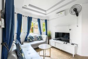 Una sala de estar con un sofá y un televisor. en Family Bungalow Kamala, en Kamala Beach