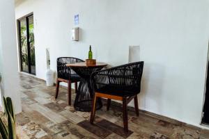 a table with two chairs and a bottle of wine on it at Hotel Brisas Bacalar in Bacalar