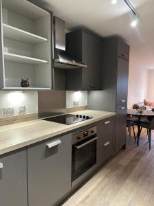 a kitchen with stainless steel appliances and a table at Birmingham City Center View in Birmingham +7 photos